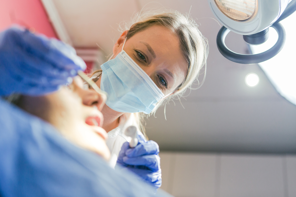 hygienist performing a teeth cleaning service